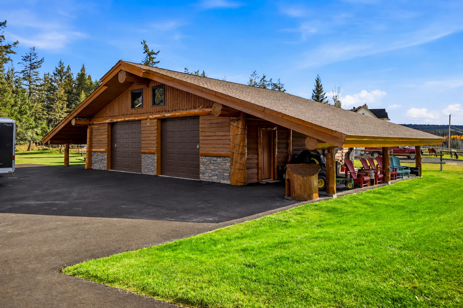 Detached log shop with garage doors, covered storage and a paved approach